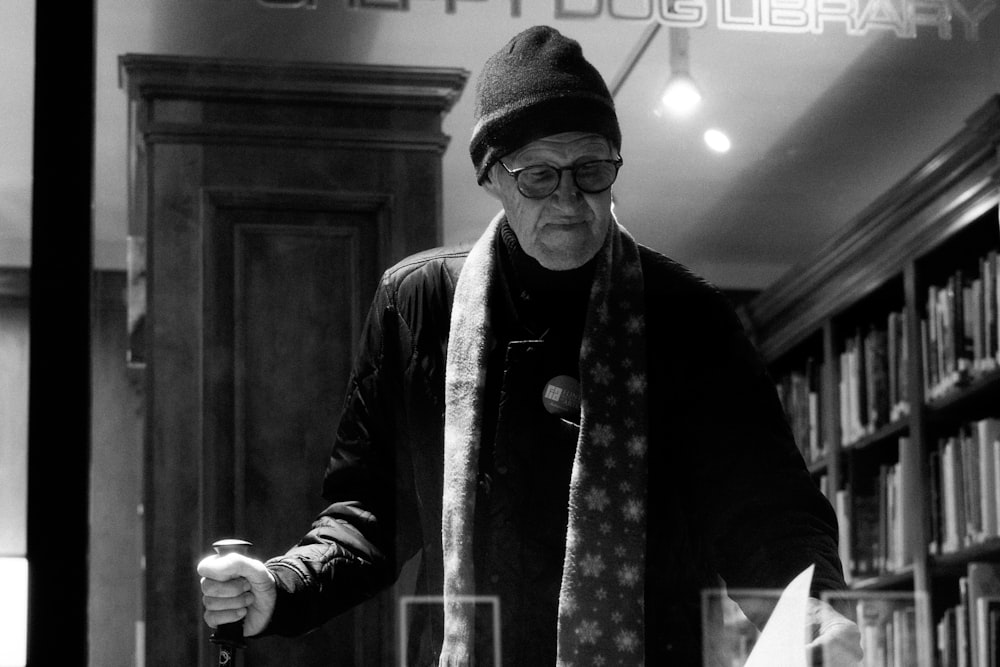 a man wearing a hat and scarf in a library