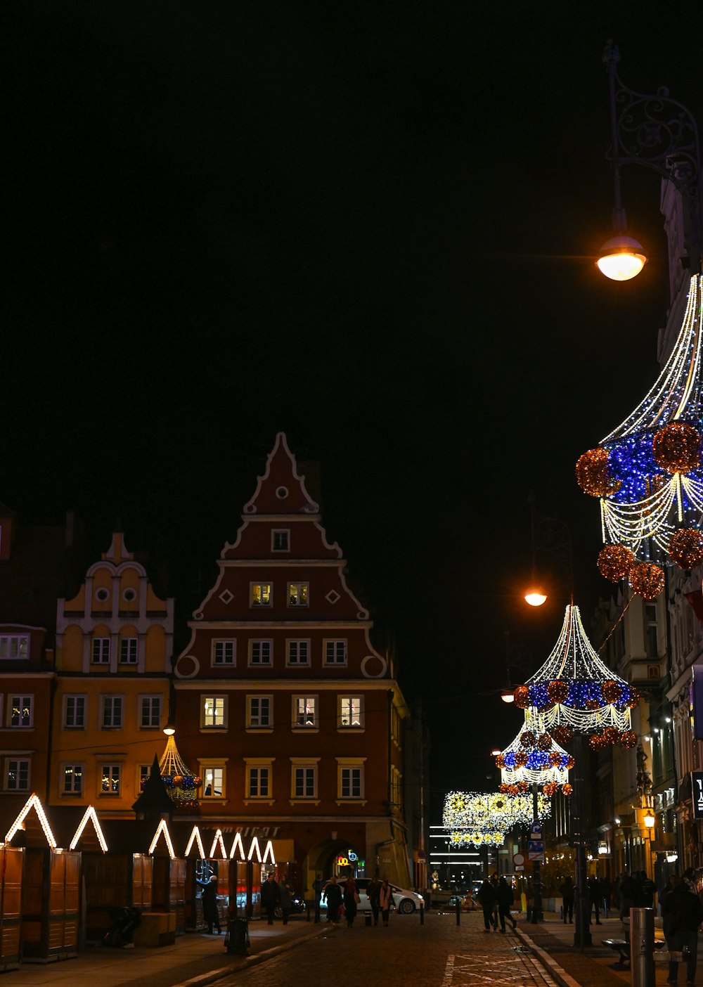 a city street at night decorated with christmas lights