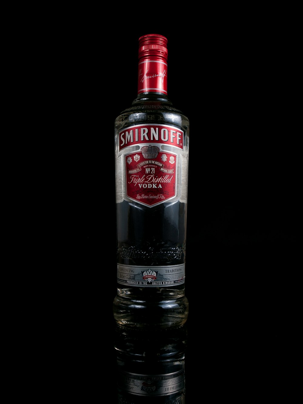 a bottle of smirnoff on a reflective surface