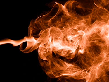 Animated orange and black motion graphic swirling on a dark background.
