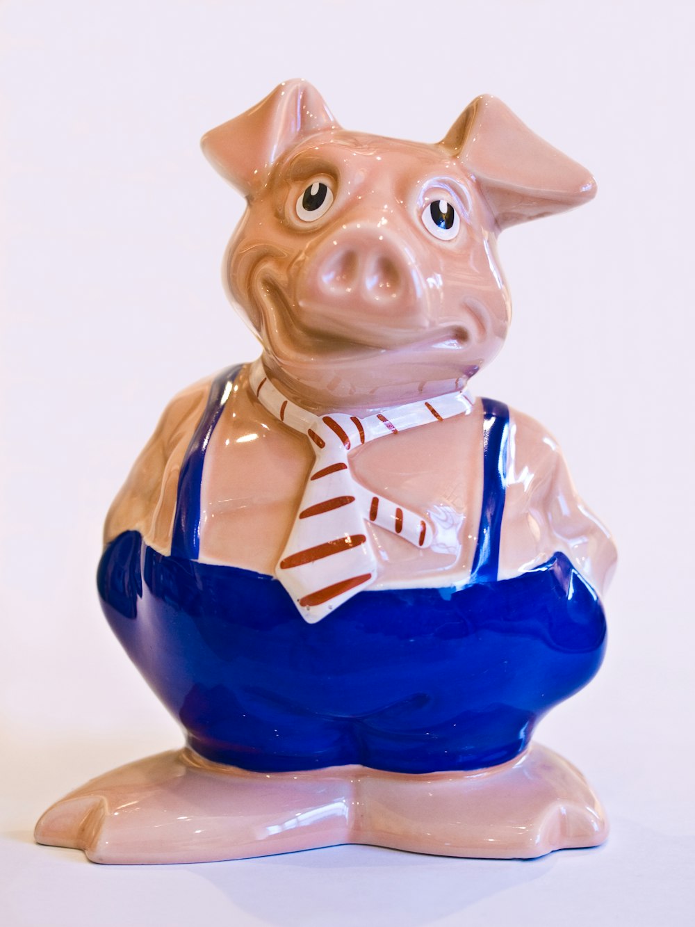 a ceramic pig figurine with a tie around its neck