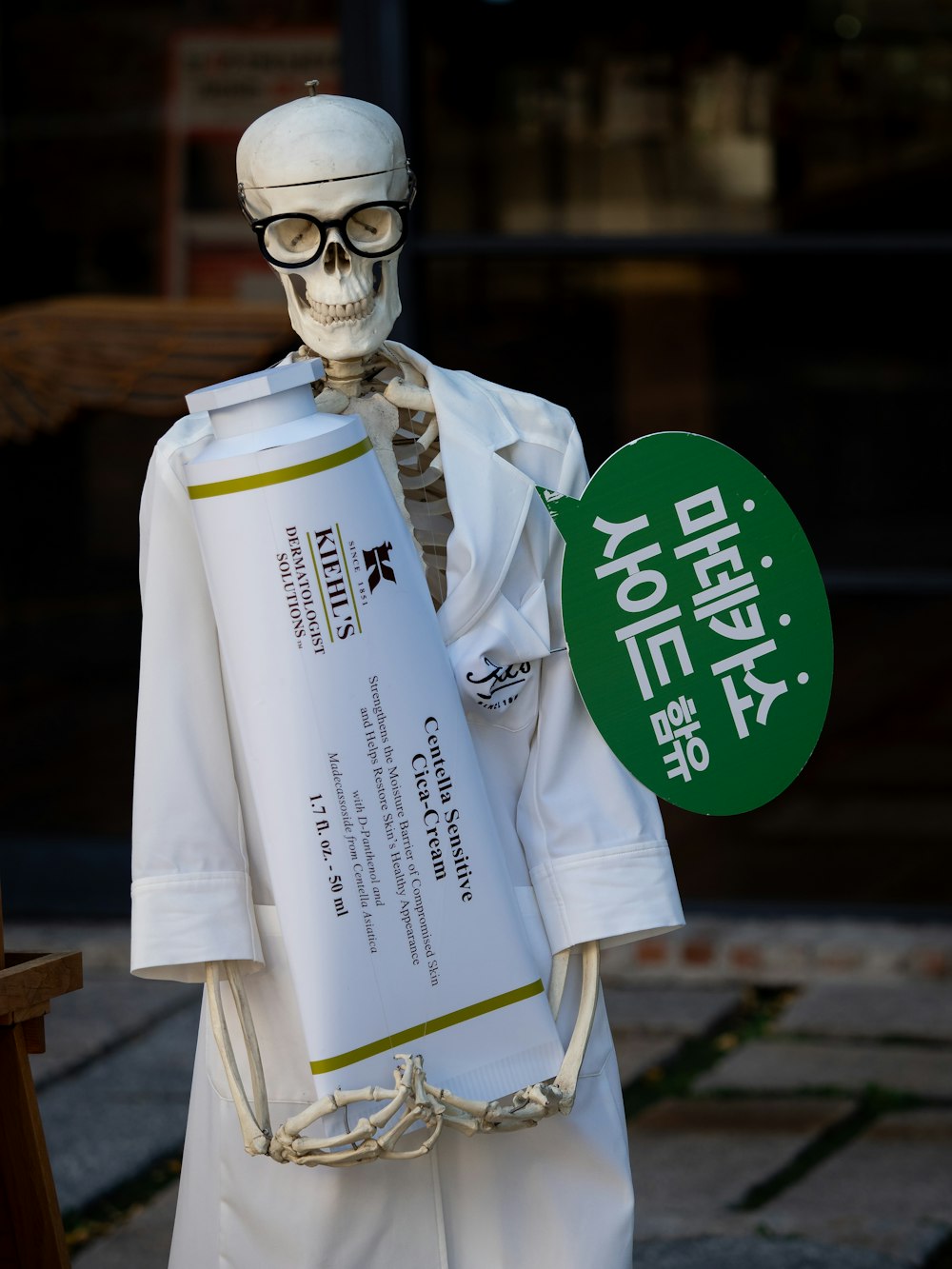 a skeleton dressed in white holding a sign