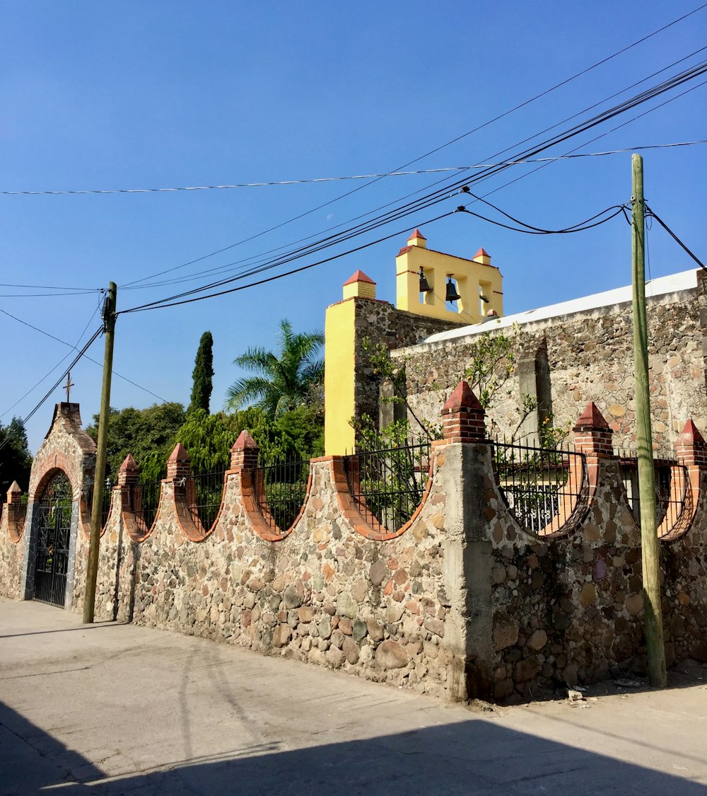 a stone wall with a clock tower in the background