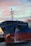 A large cargo ship, named the Fairchem Integrity, is docked at a port. Water is seen flowing from the side of the vessel near the front. The sky is filled with pink and blue hues typical of either a sunrise or sunset. The ship's hull is dark blue with some red near the waterline.
