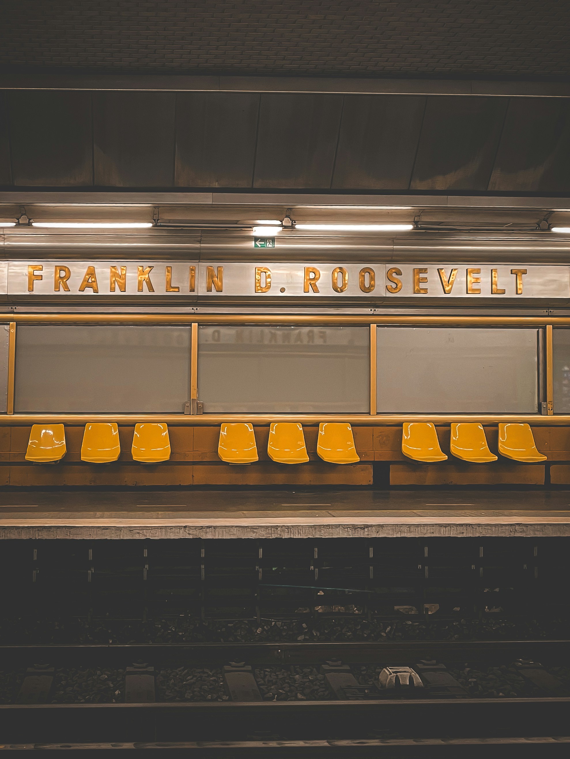 une rangée de chaises jaunes assises devant une gare