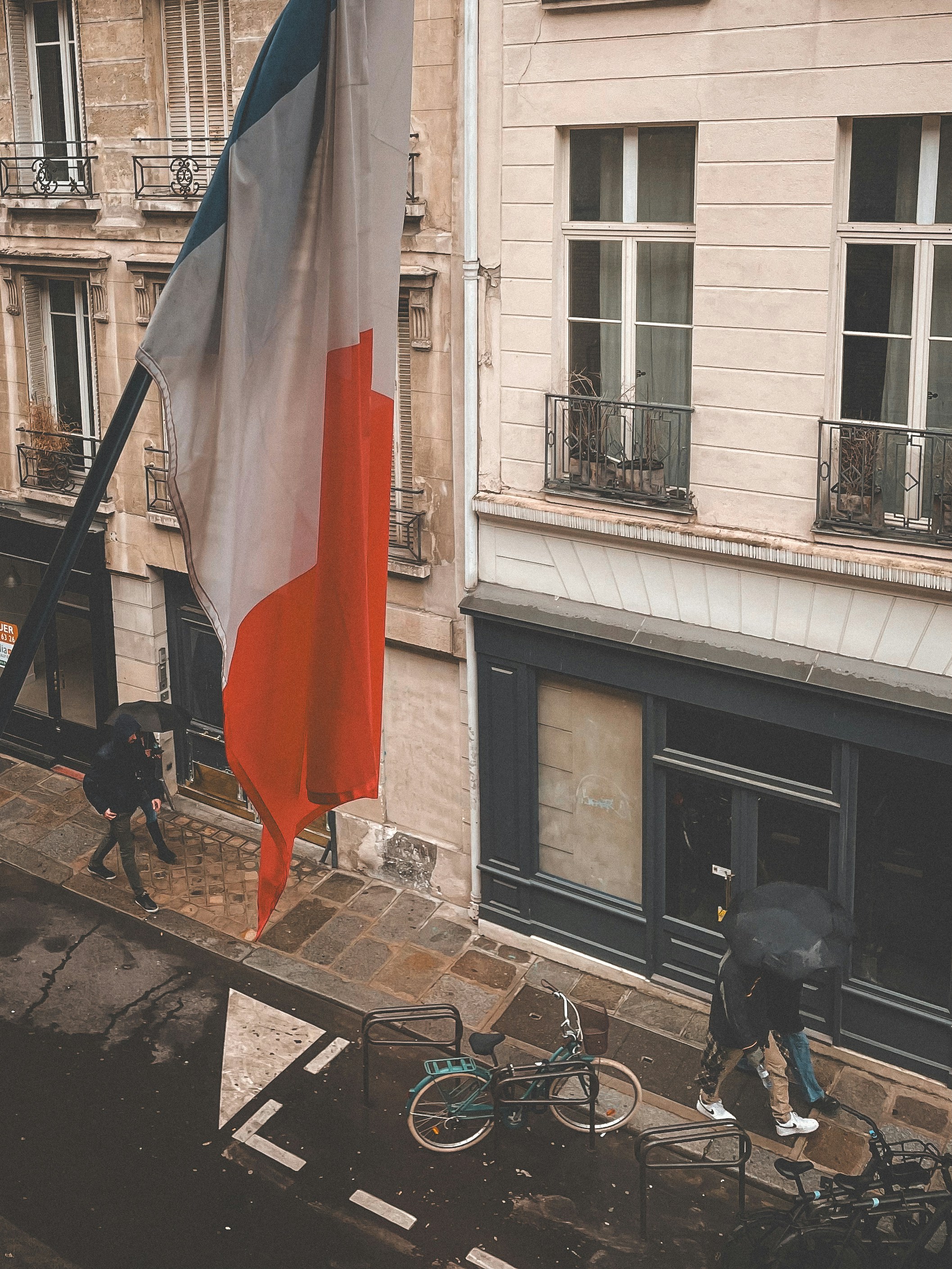 une personne avec un parapluie marchant à vélo dans une rue