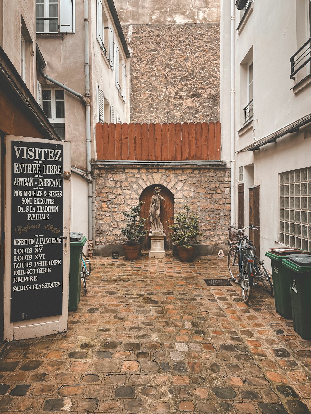 a cobblestone courtyard with a statue in the center