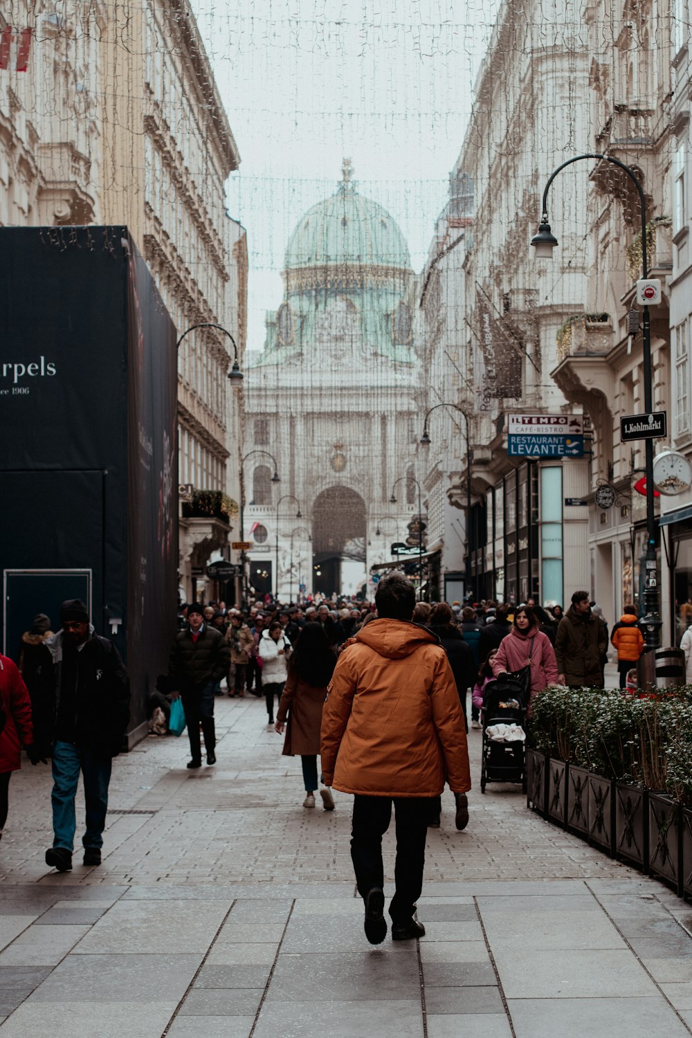 a man walking down a street next to tall buildings