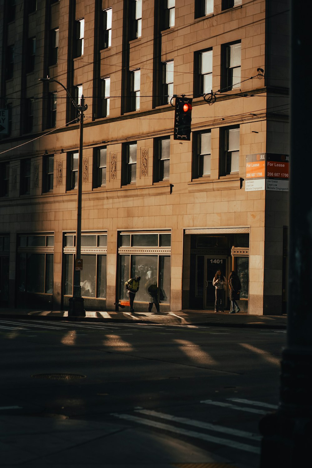 a traffic light sitting above a street next to a tall building