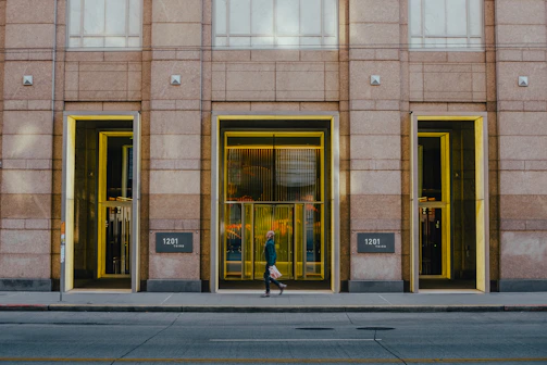 Wide sidewalk with smooth concrete surface leading to a commercial building entrance.