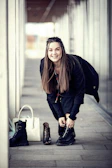 A customer happily trying on a pair of trendy boots in a cozy store corner.