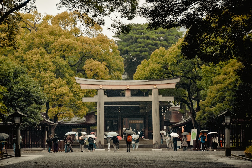 a group of people with umbrellas standing in front of a gate