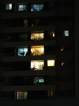 Night view of a luxury apartment building illuminated with soft navy blue lighting.