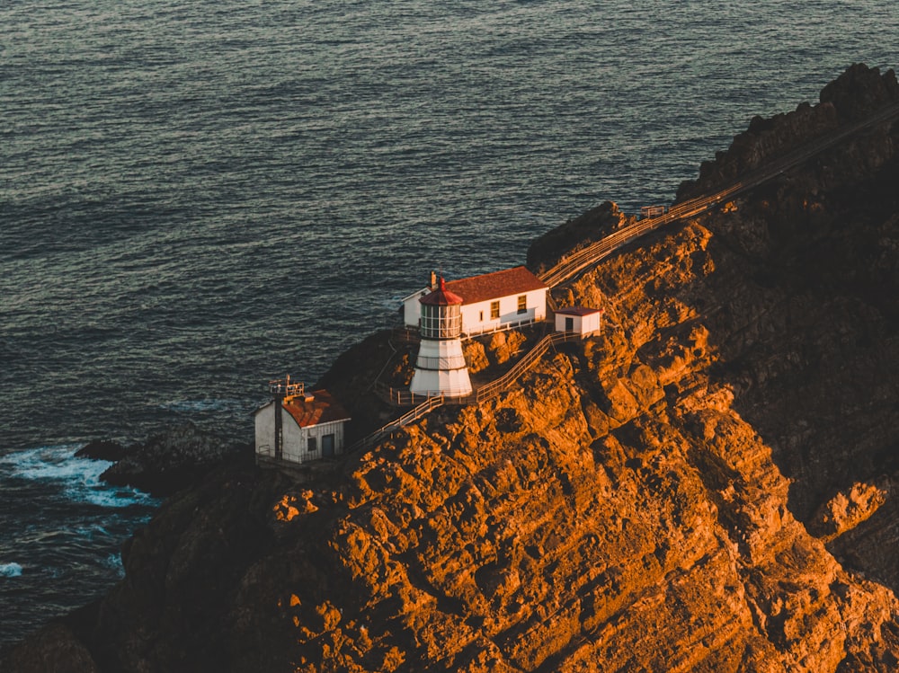 a lighthouse on a rocky cliff by the ocean