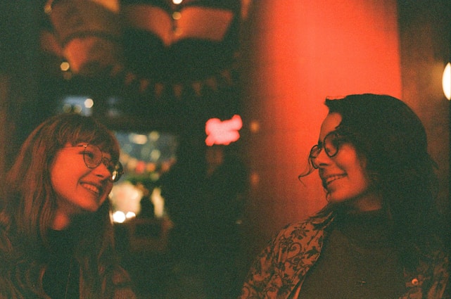 A warm, inviting scene of two people smiling and connecting face to face in a cozy café setting