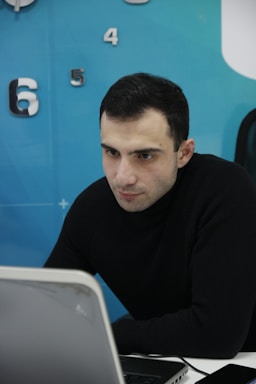 A focused professional reviewing Amazon seller account metrics on a laptop in a cozy office.