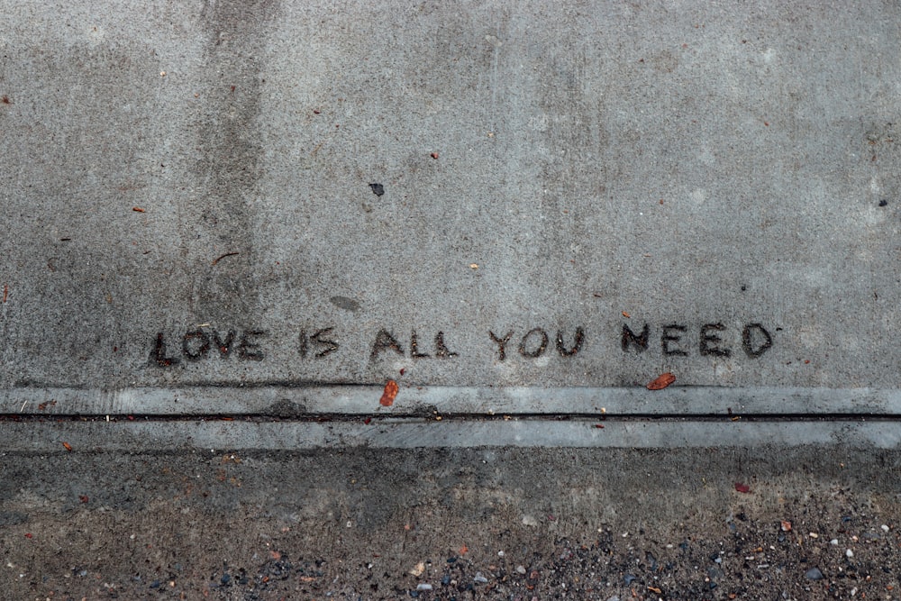 a sidewalk with graffiti written on it that says love shall you need