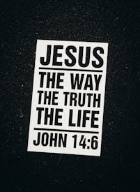 A black and white poster with a religious message. The text reads 'Jesus The Way The Truth The Life' followed by the Bible reference 'John 14:6'. The poster is set against a dark background.