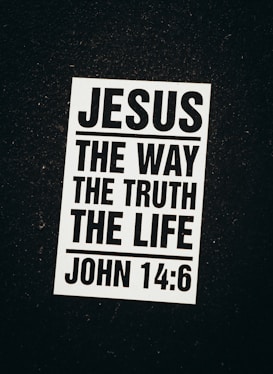 A black and white poster with a religious message. The text reads 'Jesus The Way The Truth The Life' followed by the Bible reference 'John 14:6'. The poster is set against a dark background.