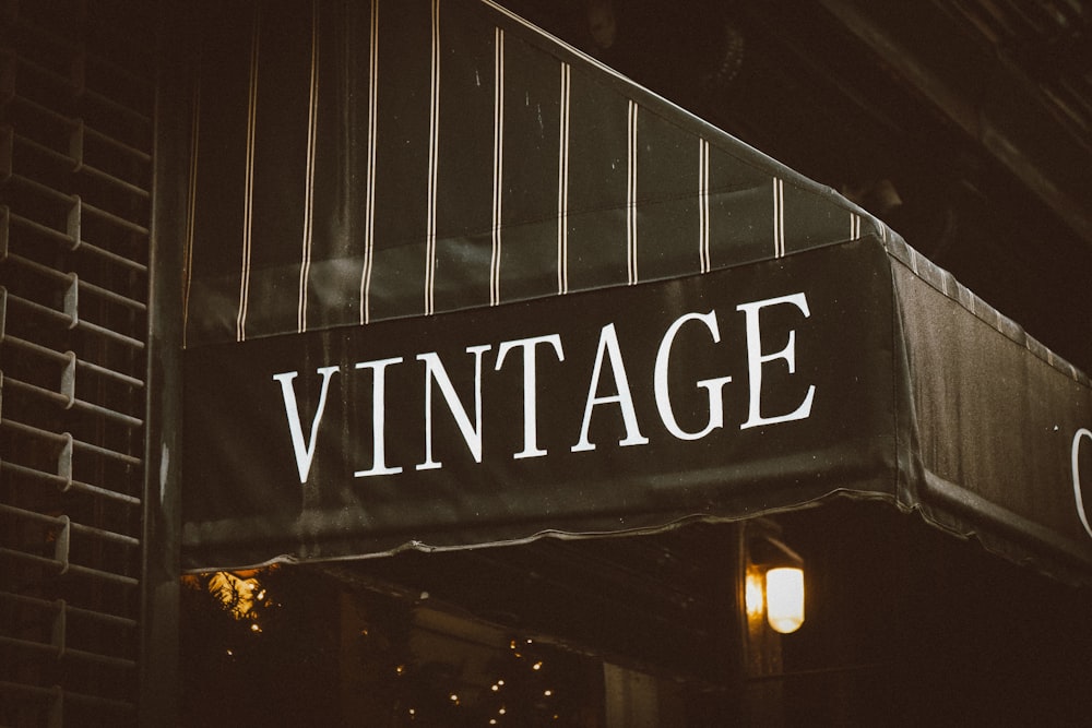 a vintage store sign hanging from the side of a building