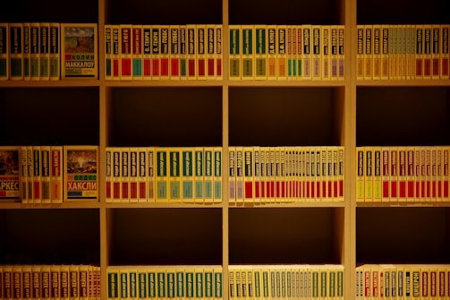 A modern wooden bookshelf with yellow and white accents in an industrial setting.