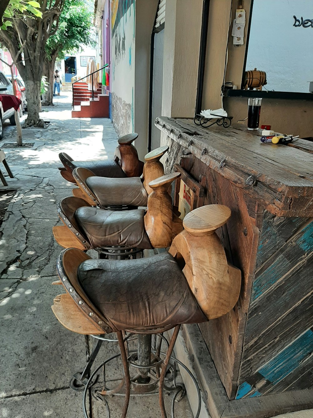 a row of wooden stools sitting next to a bar