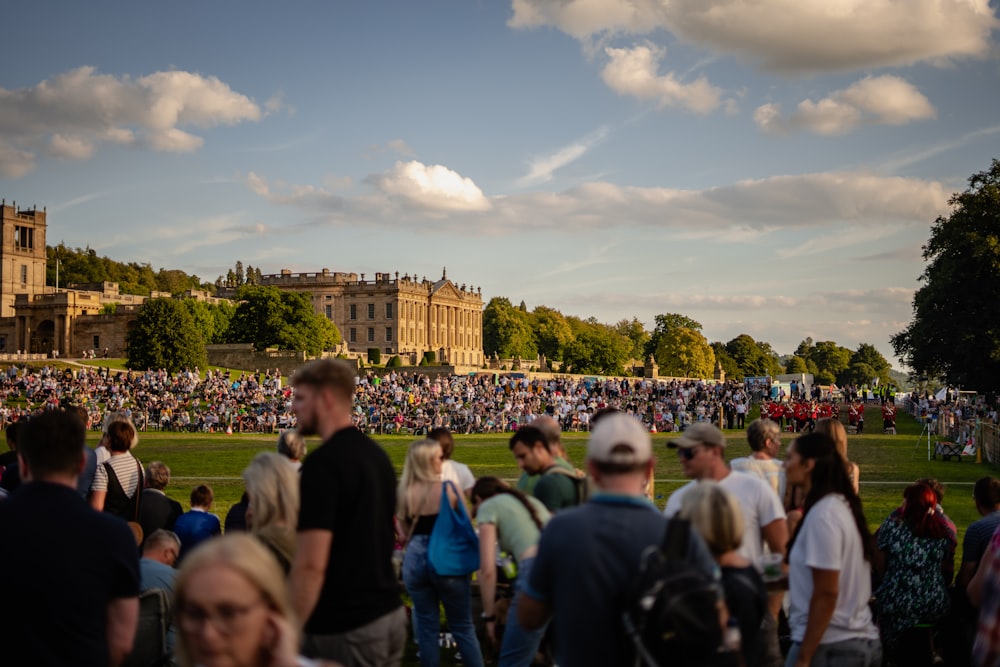 a crowd of people standing in front of a castle