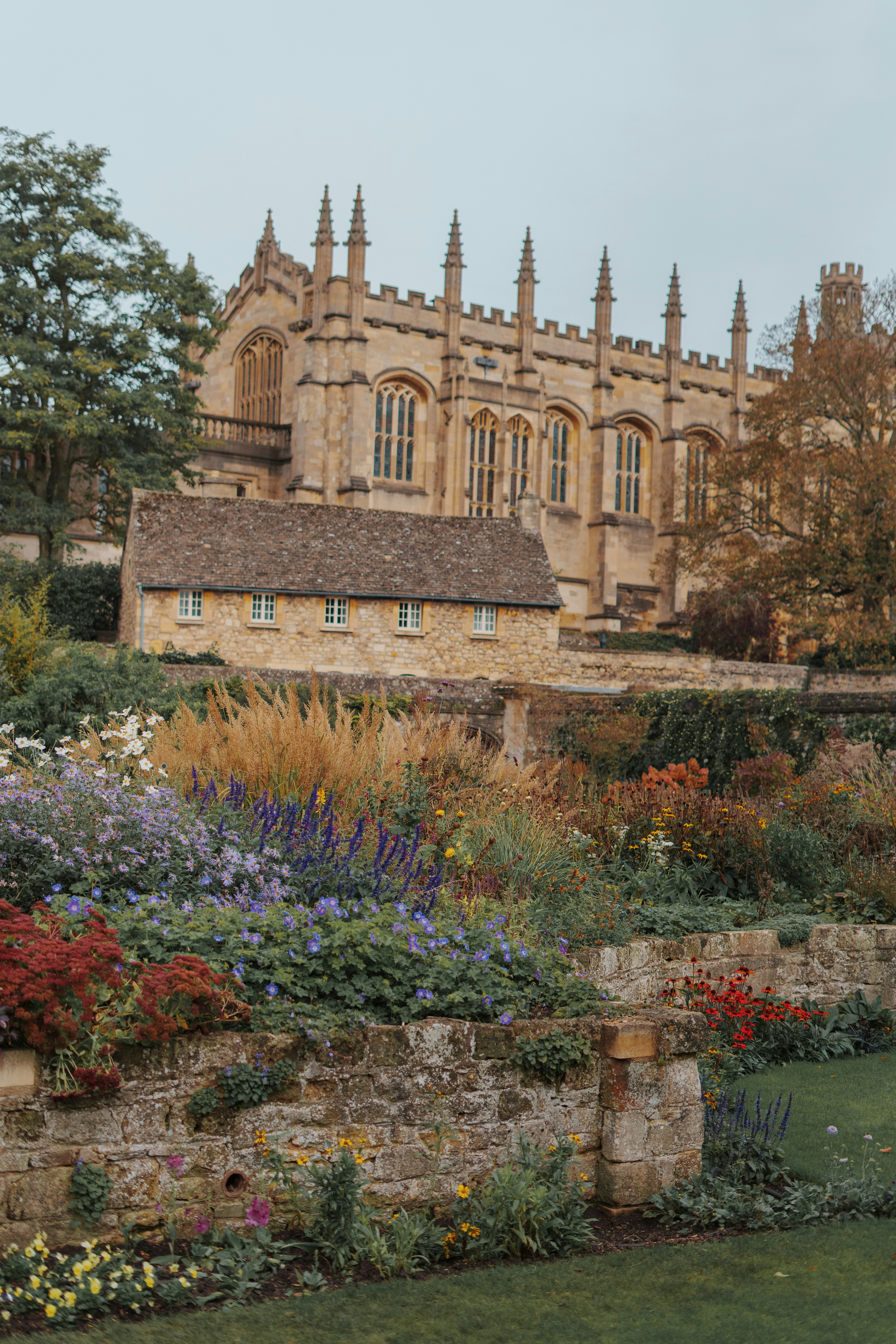 a large building with a clock tower in the middle of a garden