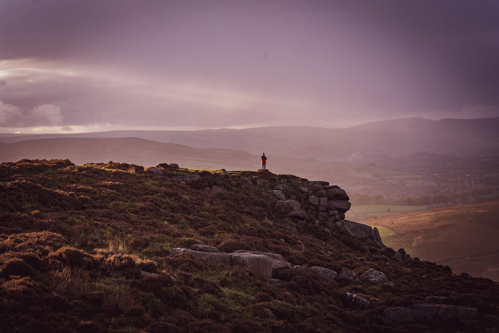 a person standing on top of a rocky hill