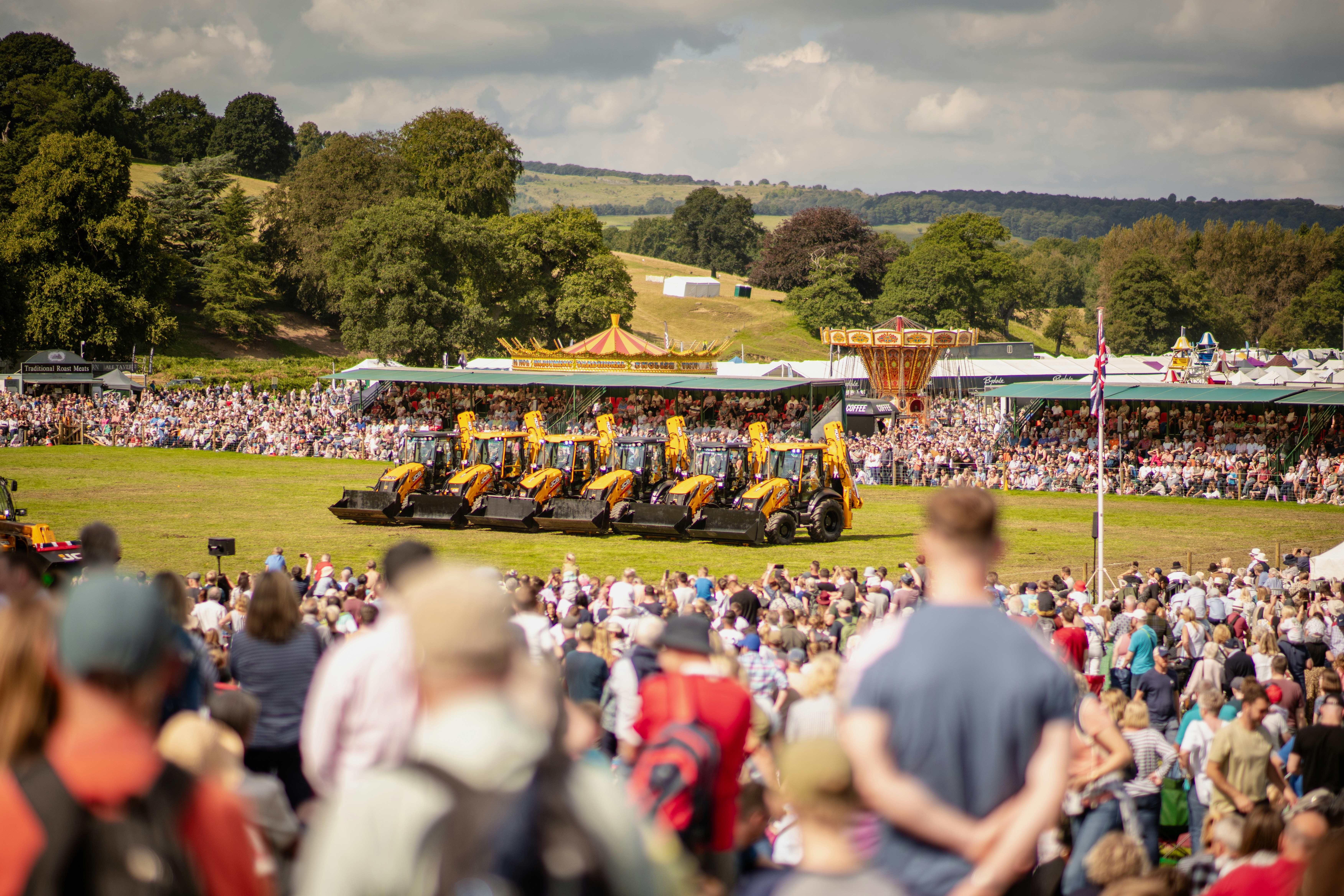 A crowd of people watching a tractor show