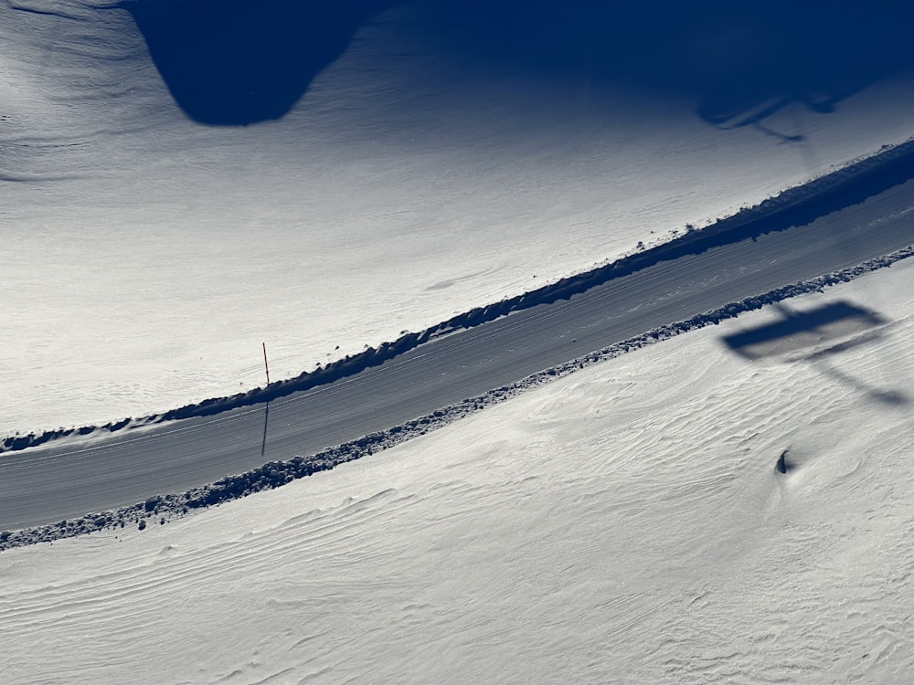 a person riding a snowboard down a snow covered slope