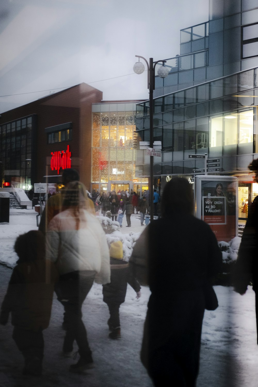 a group of people walking across a snow covered street