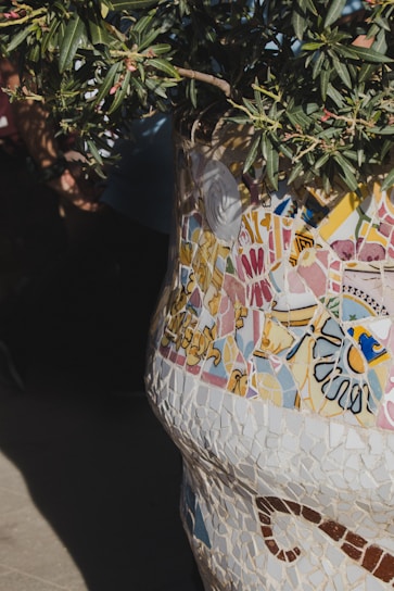 A colorful mosaic art piece displayed on a rustic wooden table.
