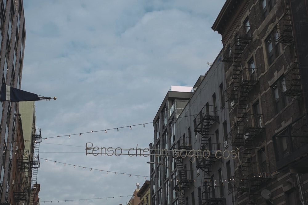 a city street with buildings and a string of lights