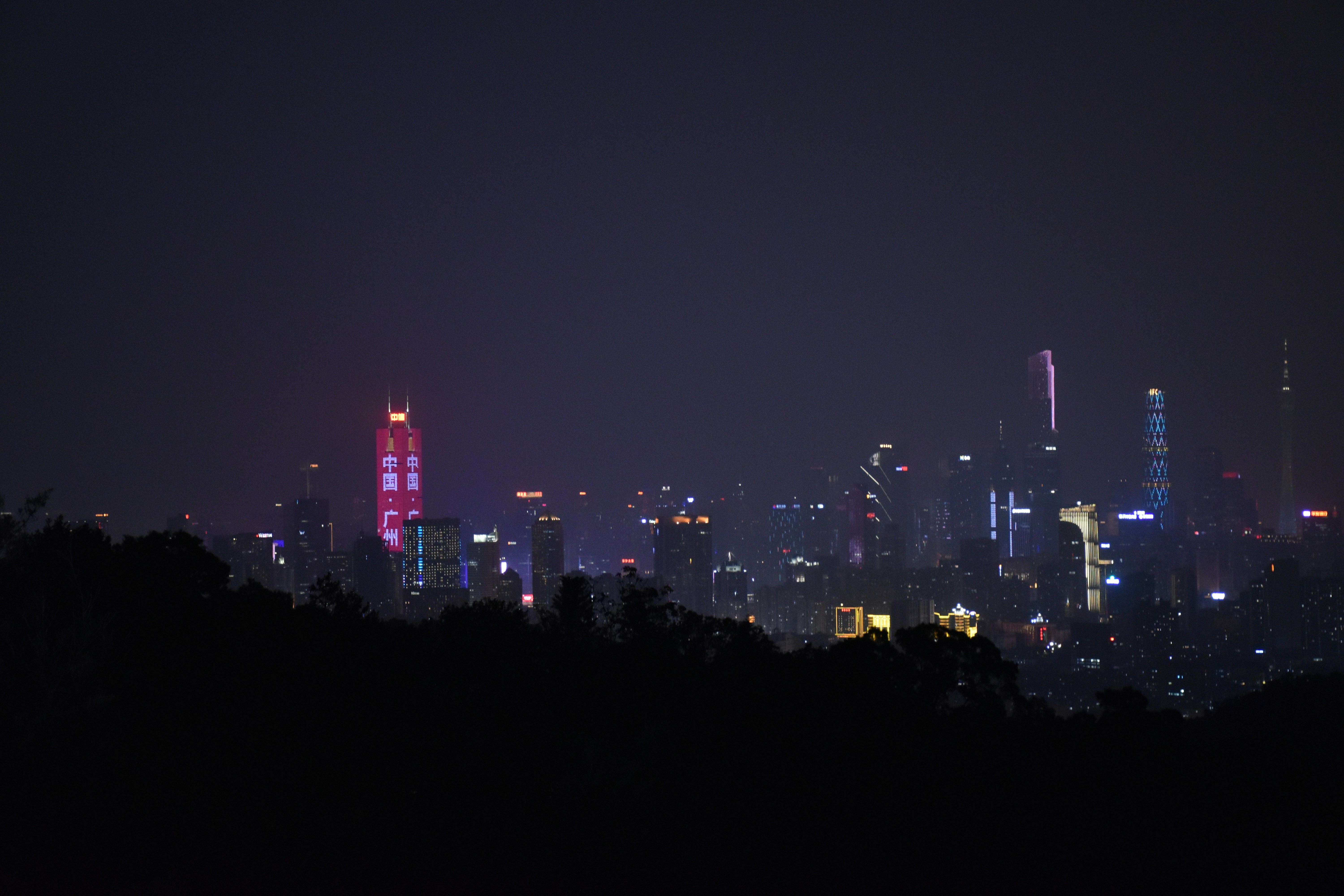 a view of a city at night from the top of a hill