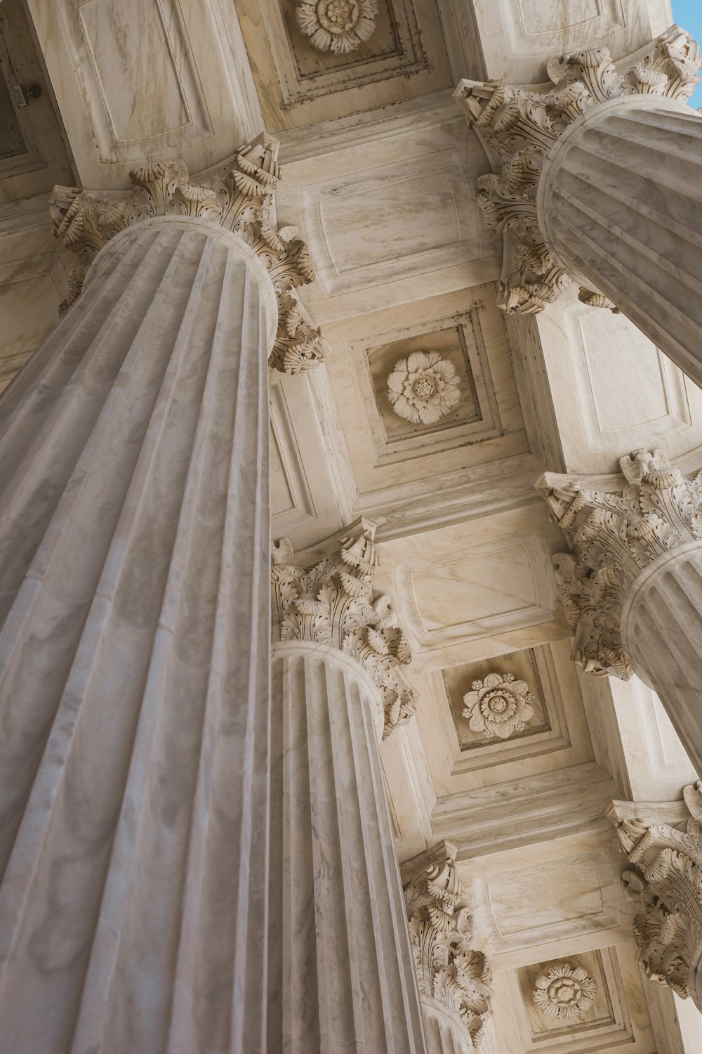 the ceiling of a building with columns and a clock