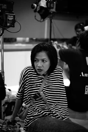 A candid portrait of Nancy Robinson thoughtfully reviewing her latest film edits in a sunlit studio.