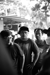 A group of friends smiling and dancing together outdoors wearing wireless headphones.