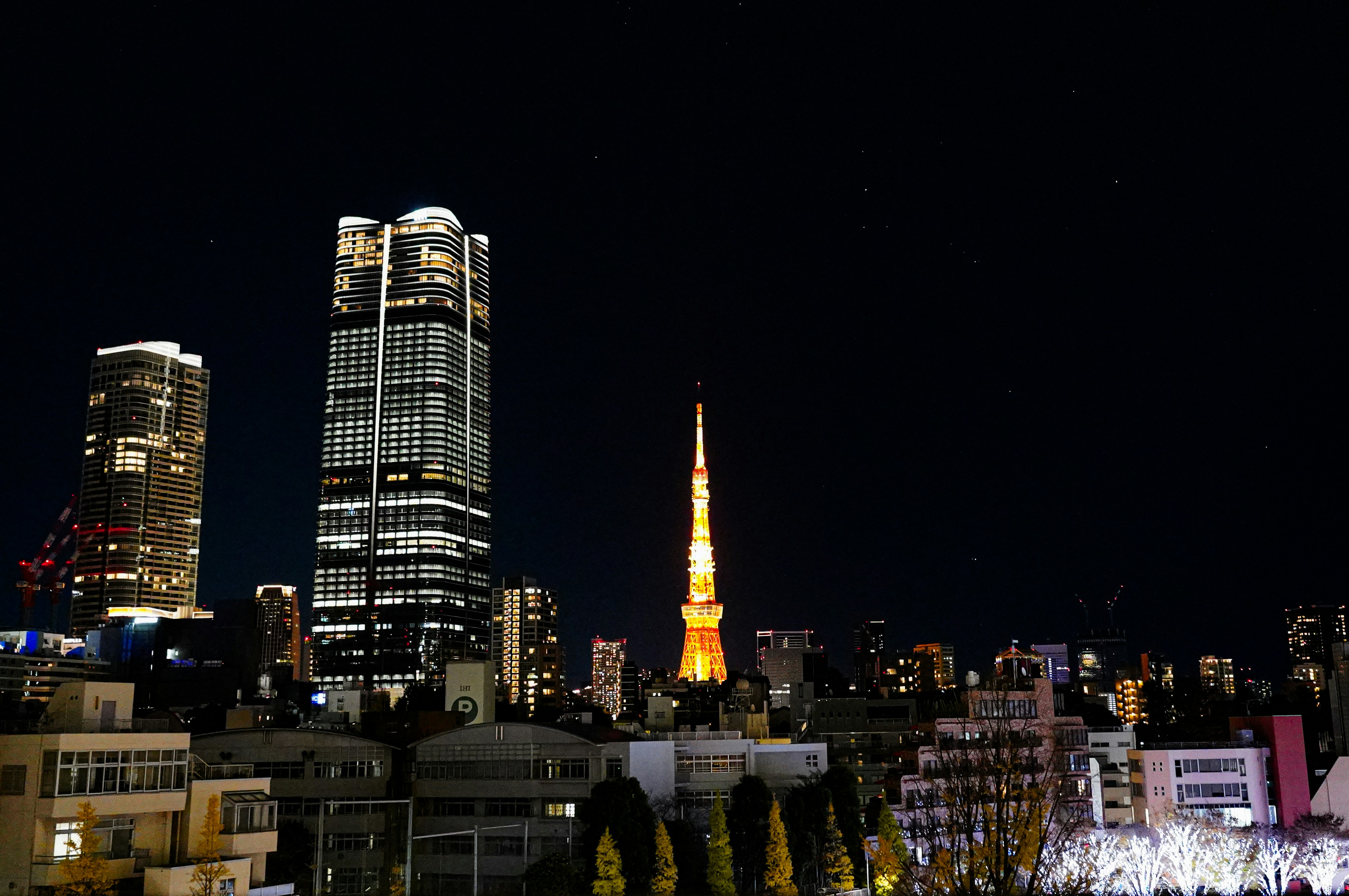 Tokyo city skyline at night with financial district lights reflecting on water, Japan cityscape dark atmosphere