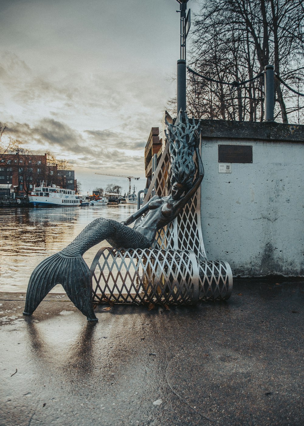 a statue of a mermaid sitting on top of a net