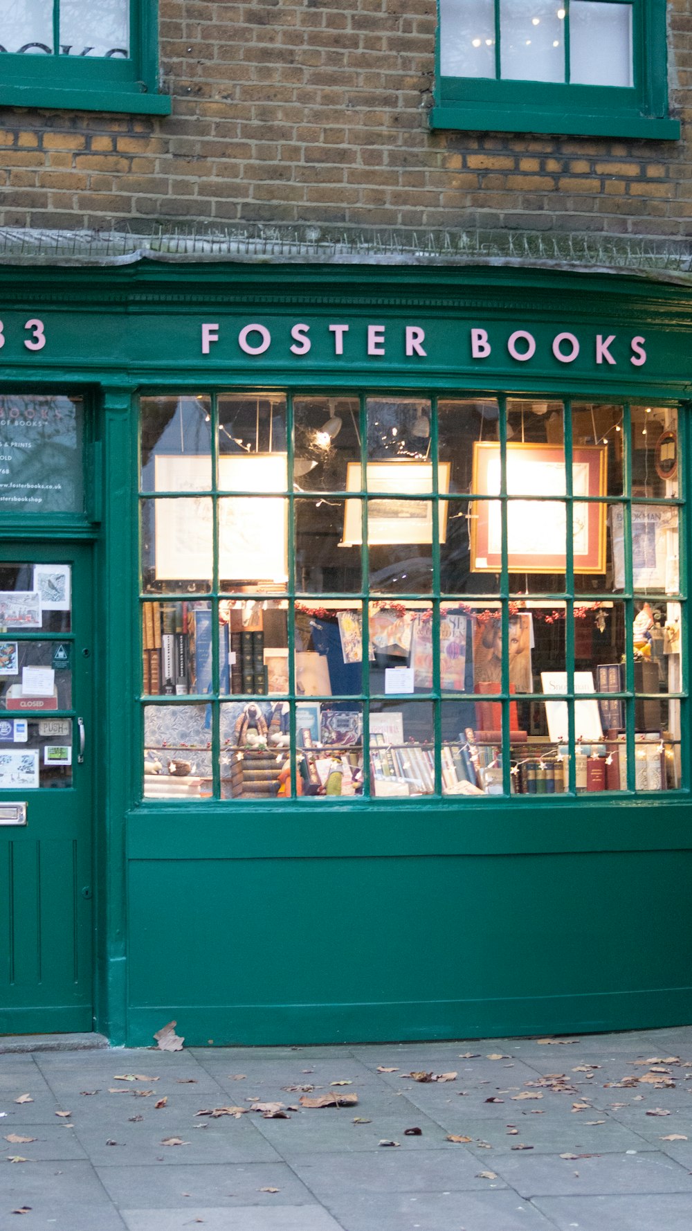 a green store front with a lot of books on display