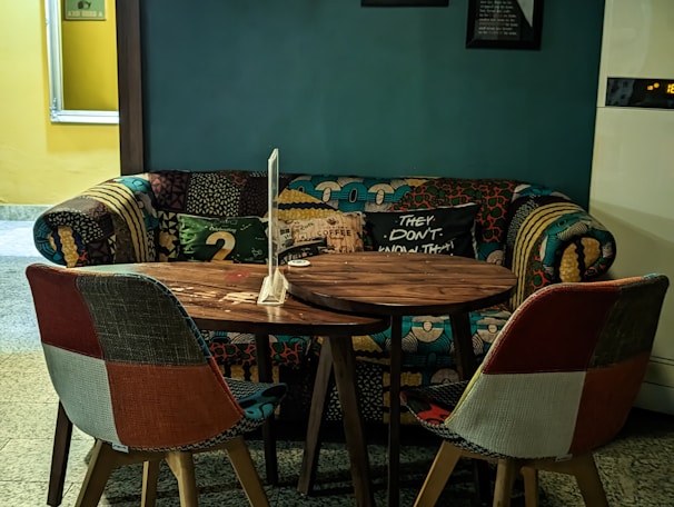 A vibrant lounge area with colorful cushions on a durable fabric sofa, complemented by a rustic wooden side table.