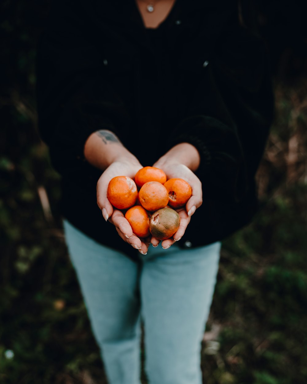 a person holding a handful of fruit in their hands