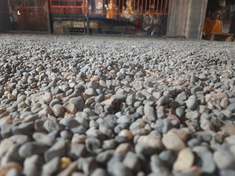 Close-up of recycled driveway gravel being spread by a worker.