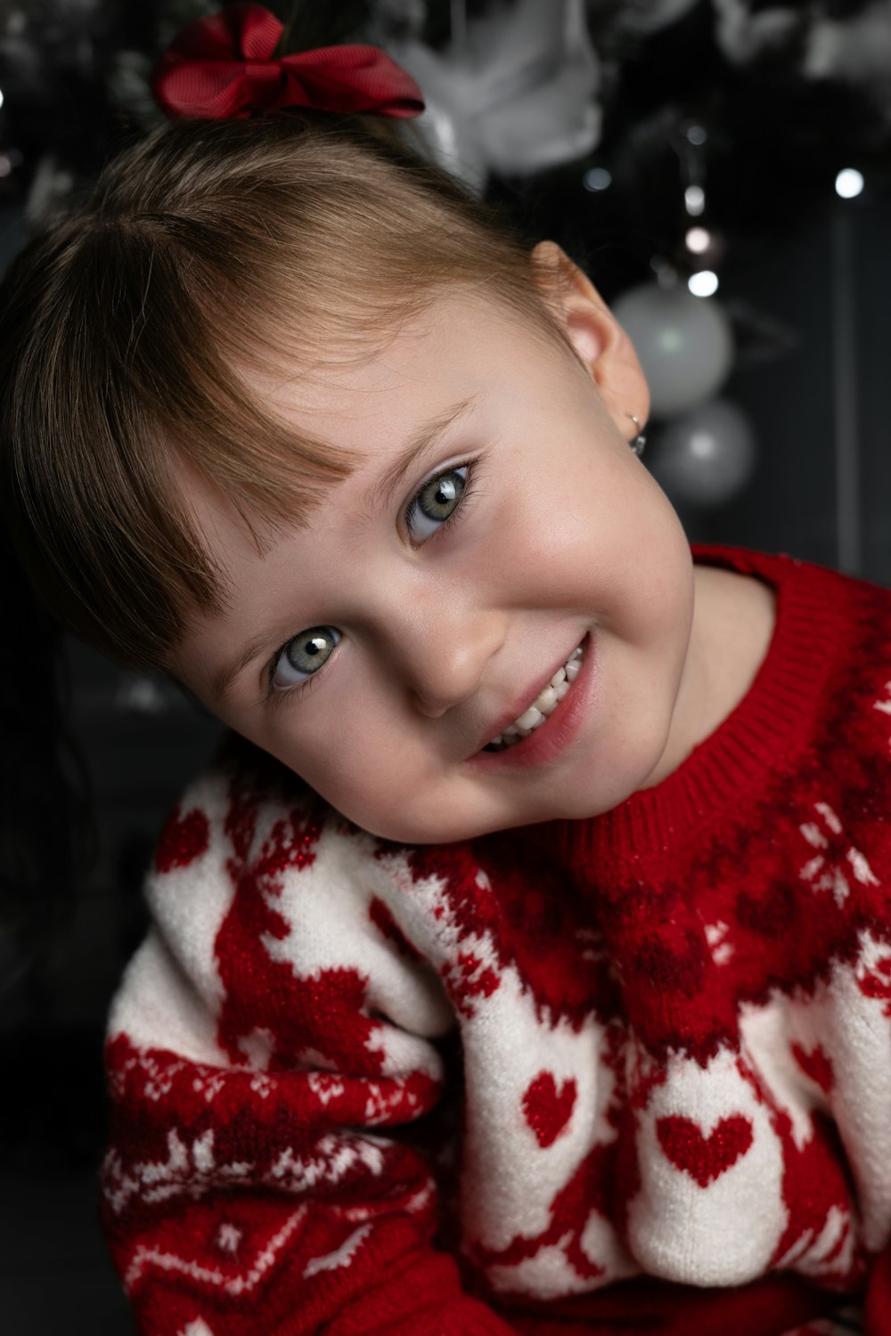 a little girl wearing a red and white sweater