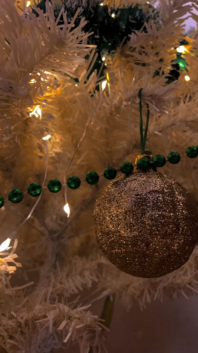 Close-up of a beautifully decorated artificial Christmas tree with warm white lights and colorful ornaments.