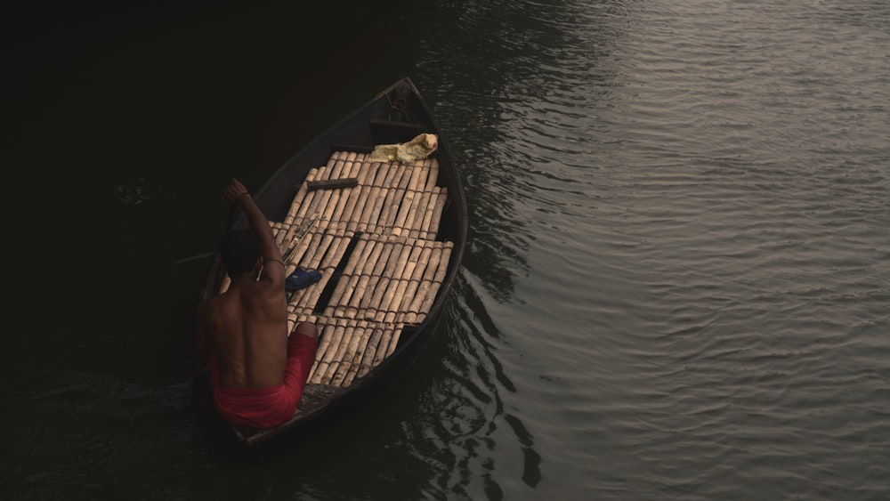 une personne dans une petite embarcation sur un plan d’eau ;