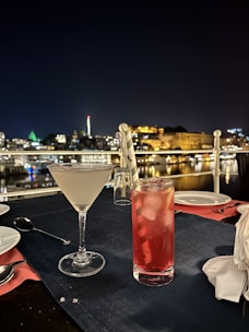 Gourmet dining setup with candlelight on a terrace overlooking a city skyline at night.