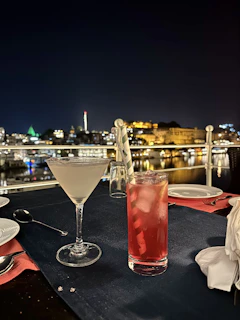 A beautifully set outdoor dining experience overlooking a sparkling city skyline at dusk.
