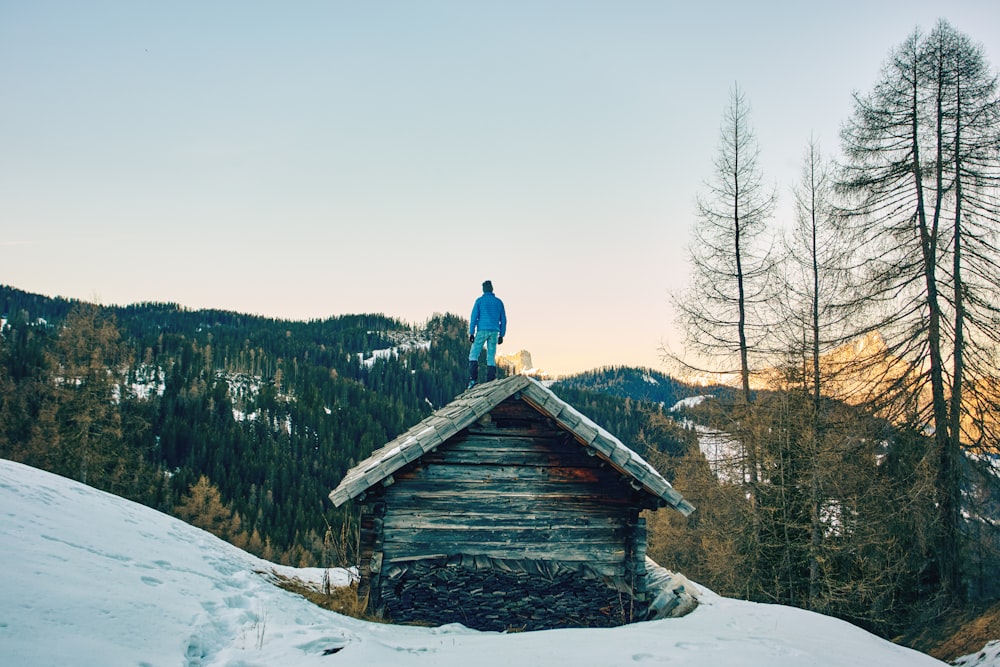 a man standing on top of a roof in the snow